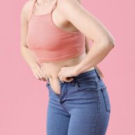 Woman struggling with belly fat and unable to fit into her jeans during perimenopause